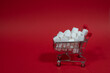 Einkaufswagen mit Zuckerwürfel auf roten Hintergrund mit Platz für Text
