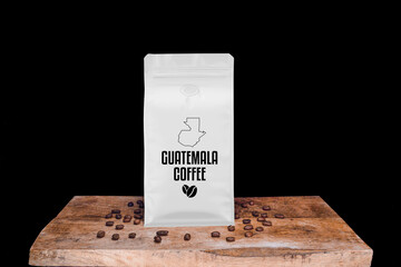 Wall Mural - Guetamala coffee beans and white package on wooden board with black isolated background