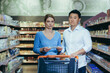 © Liubomir - Upset young couple in supermarket, man and woman looking at camera poor have no opportunity and money to shop, multiracial family.