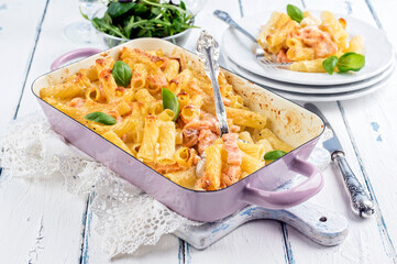 Traditional German pasta bake topped with salmon and cheese and served as a close-up in a shabby chic casserole dish