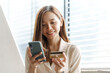 © NanSan - Young pretty asian female using credit card to do online product shopping on her mobile, cashless concept.