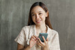 © NanSan - Surprised young pretty asian woman using a smartphone.