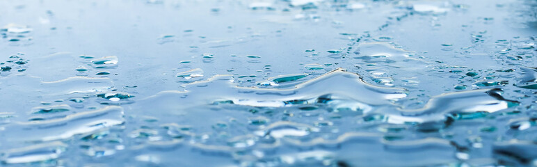 Pattern of water drops in a shiny metallic surface with table reflections