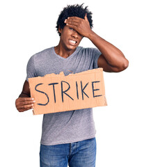 Sticker - Handsome african american man with afro hair holding strike banner cardboard stressed and frustrated with hand on head, surprised and angry face