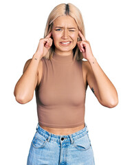 Poster - Beautiful young blonde woman wearing casual style with sleeveless shirt covering ears with fingers with annoyed expression for the noise of loud music. deaf concept.