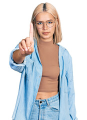 Poster - Beautiful young blonde woman wearing glasses pointing with finger up and angry expression, showing no gesture