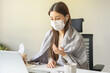 Sick asian young woman wearing mask wrapped blanket have headache have fever, flu and using laptop computer consulting with doctor online, telehealth at home. Health care people on virus seasonal.