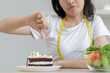 Diet, Dieting asian young woman, girl hand showing thumb up deny, reject chocolate cake, dessert food, choose eat green salad vegetables when hungry. Nutritionist of healthy, nutrition of weight loss.