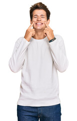 Wall Mural - Handsome caucasian man wearing casual white sweater smiling with open mouth, fingers pointing and forcing cheerful smile