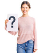 © Krakenimages.com - Beautiful caucasian woman with blonde hair holding question mark looking positive and happy standing and smiling with a confident smile showing teeth