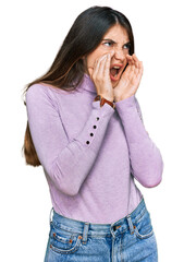 Wall Mural - Young beautiful teen girl wearing turtleneck sweater shouting angry out loud with hands over mouth