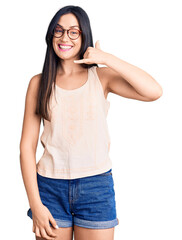 Poster - Young beautiful caucasian woman wearing casual clothes and glasses smiling doing phone gesture with hand and fingers like talking on the telephone. communicating concepts.