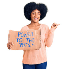 Poster - Young african american girl holding power to the people banner smiling happy pointing with hand and finger to the side