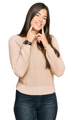 Wall Mural - Young brunette woman wearing casual winter sweater smiling with open mouth, fingers pointing and forcing cheerful smile