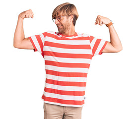 Sticker - Handsome caucasian man with beard wearing casual clothes and glasses showing arms muscles smiling proud. fitness concept.