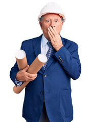 Wall Mural - Senior handsome grey-haired man wearing architect hardhat holding blueprints covering mouth with hand, shocked and afraid for mistake. surprised expression