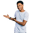© Krakenimages.com - Young african american man wearing casual white t shirt inviting to enter smiling natural with open hand