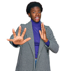 Sticker - Young african american girl wearing casual clothes afraid and terrified with fear expression stop gesture with hands, shouting in shock. panic concept.