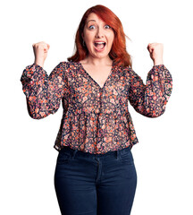 Wall Mural - Young beautiful redhead woman wearing casual t-shirt celebrating surprised and amazed for success with arms raised and open eyes. winner concept.