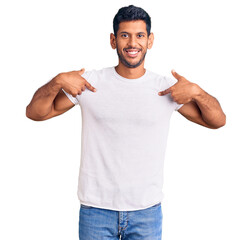 Sticker - Young latin man wearing casual clothes looking confident with smile on face, pointing oneself with fingers proud and happy.