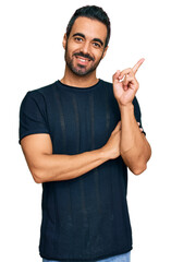 Sticker - Young hispanic man wearing casual clothes smiling happy pointing with hand and finger to the side