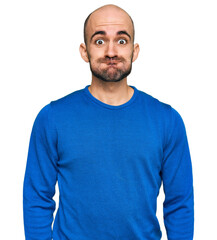 Canvas Print - Young hispanic man wearing casual clothes puffing cheeks with funny face. mouth inflated with air, crazy expression.