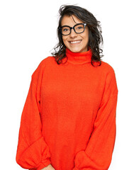 Wall Mural - Young hispanic woman wearing casual clothes and glasses looking positive and happy standing and smiling with a confident smile showing teeth