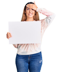 Sticker - Beautiful young woman holding blank empty banner stressed and frustrated with hand on head, surprised and angry face