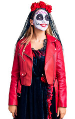 Wall Mural - Woman wearing day of the dead costume over background looking away to side with smile on face, natural expression. laughing confident.