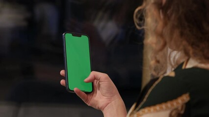 Girl Using Smartphone in Vertical Mode with Green Mock-up Screen, Doing Swiping, Scrolling Gestures. Internet Social Networks Browsing News