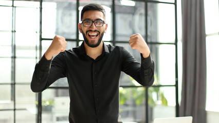 young businessman celebrating success in his home office