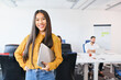 © baranq - Successful female entrepreneur or employee at coworking office. Portrait of smiling Asian women with laptop at startup office