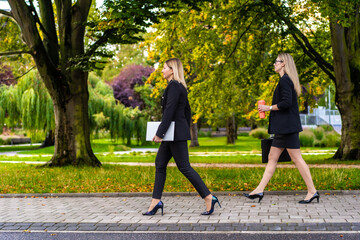  Two beautiful women walking in city park