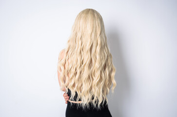 beautiful woman with long shiny blond hair on white background. curly blond hair