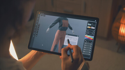 Male 3D designer creating design of clothes in 3D modeling application using tablet computer and digital pencil while working remotely on freelance project