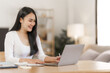 © NanSan - Happy smart asian woman freelancer working with laptop while live in the room.