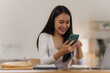 © NanSan - Portrait of smile asian woman freelancer using mobile phone at home office.
