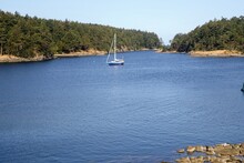 A Beautiful Sunny Summer Day In The Gulf Islands With Sailboats Resting On The Calm Ocean Surrounded By Scenic Forested Coastline