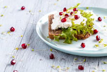 Dark Bread Sandwich With Grains. Top With Green Lettuce, Cottage Cheese, Pomegranate, And Sprouts. Everything On A Rustic Wooden Table.