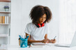 © Phushutter - Young pretty african amerian woman studying online with laptop at living room.
