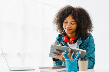 Wall Mural - Young pretty african amerian woman studying online with laptop at living room.