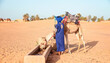 © muratart - Camel drinking water from a well in the Sahara desert