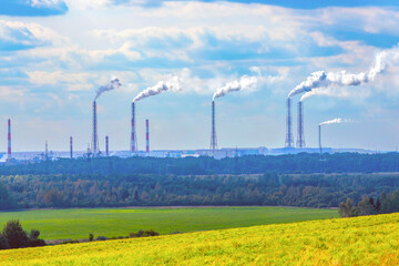 Industrial landscape. The pipes of a chemical fertilizer plant emit toxic smoke, carbon dioxide, polluting the air. The concept of transition to green technologies, energy crisis.