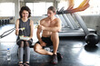 © feeling lucky - lovely caucasian couple fitness man and woman take a rest and eating salad in gym after finish fitness training while laughing and smiling