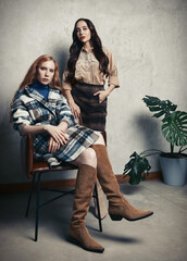 Retro fashion: two beautiful young women indoors. Vintage portrait of pretty girls in seventies style