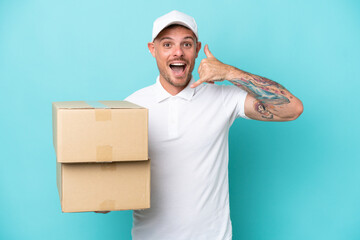 Wall Mural - Delivery caucasian man isolated on blue background making phone gesture. Call me back sign