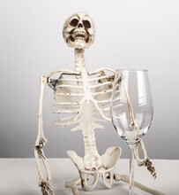 Alcohol Addiction. Skeleton Holding Empty Glass. Alcoholism, Mental And Physical Health Problems Concept. High Quality Photo