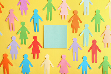 Wall Mural - Many different paper human figures around blank card on yellow background, flat lay with space for text. Diversity and inclusion concept