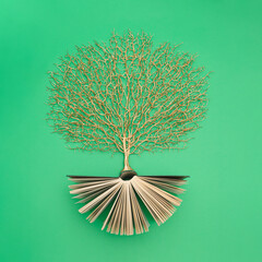 Wall Mural - Golden tree growing from the old book, Education and knowledge concept. For book lovers. Flat lay.
