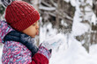 © Tatyana - Happy little African-American girl in a red hat and overalls blowing snow off the hand.Winter, Christmas and Happy New Year concept.